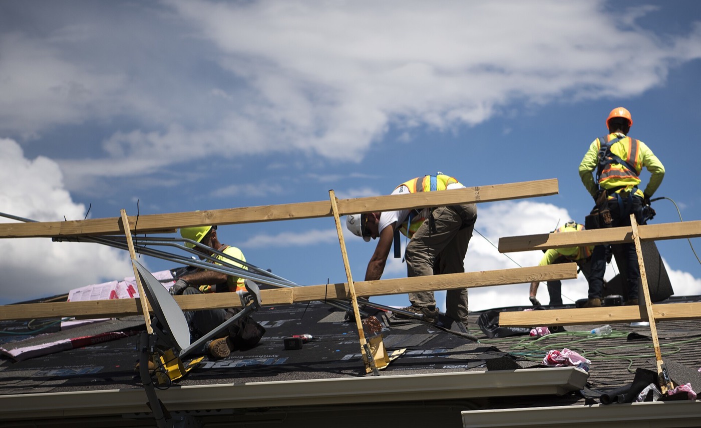 A crew installing new shingles on a roof